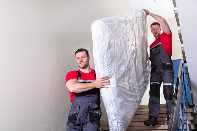 heavy lifting workers transporting a box spring out of a building in Burns Harbor IN